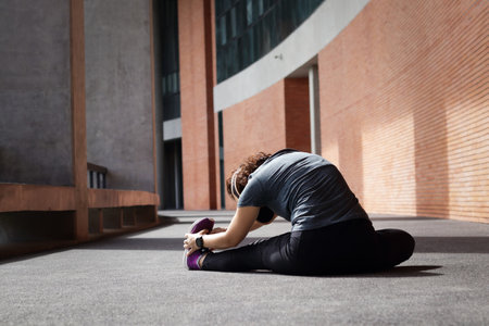 Asian woman exercising in the morning sitting stretching Before and after exercising on concrete...