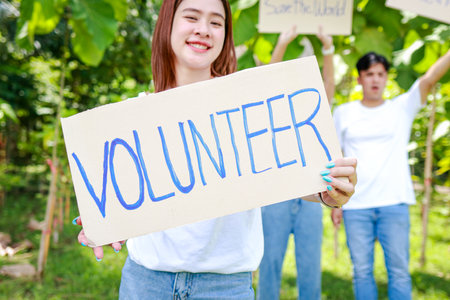 Group of young Asian volunteers holding paper banners Help campaign to save the environment. save the worldの写真素材