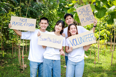 Group of young Asian volunteers holding paper banners Help campaign to save the environment. save the worldの写真素材