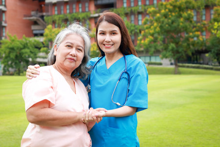 Asian female doctor with elderly female patient standing outdoors. Medical services in hospitals. senior health insurance. copy spaceの写真素材