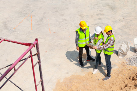 Group of architects, engineers and construction contractors Standing at the job site holding a...