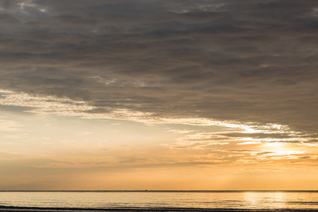 Rays of the rising sun over the ocean.の写真素材