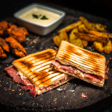 Pepperoni paninos, rustic potatoes and spicy fried chicken with house sauce.の写真素材