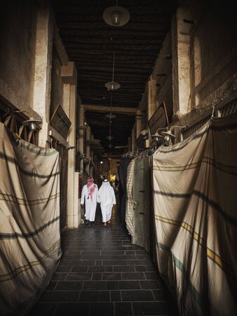 Qataris in traditional clothes walking through Souq Waqif