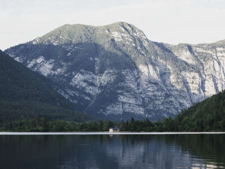 Boat house at lake Hallstatt with massive mountain in background