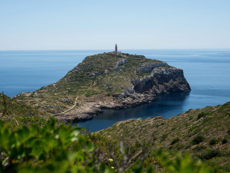 Panorama view of Punta Anciola lighthouse on seaside green hill Cabrera National Park Mallorca Balearic Islands Spainの写真素材