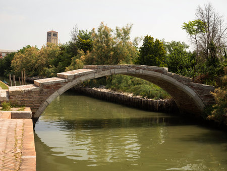 Rustic historic brick arch Devils Bridge Ponte del Diavolo canal Torcello Island Venetian Lagoon...