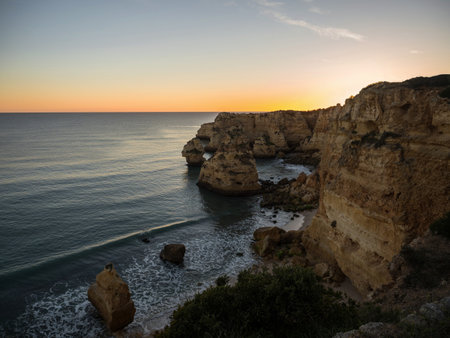 Sunset panorama view of rock cliff coast navy beach Praia da Marinha Caramujeira Lagoa Algarve atlantic ocean sea Portugal Europeの写真素材