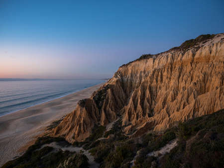 Sunset panorama view of Arriba Fossil da Praia da Gale Fontainhas beach hoodoo fairy chimney earth pyramid rock formations canyon erosion, atlantic ocean Melides Portugal Europeの写真素材