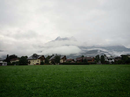 Alpine mountain panorama view in town village of Saalfelden at green grass meadow Salzburger Land,...