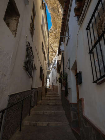 Narrow cobblestone street alley in charming white town village of Setenil de las Bodegas in Cadiz Andalusia, Spain Europeの写真素材