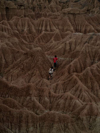 Hikers walking in Tatacoa desert tropical dry forest red sand stone labyrinth in Villavieja Neiva Huila Colombia South Americaの写真素材