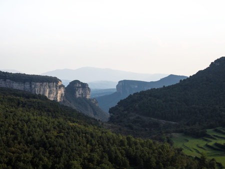Panorama view of stone rock cliff gorge canyon with green grass meadow fields near Tavertes Osona...