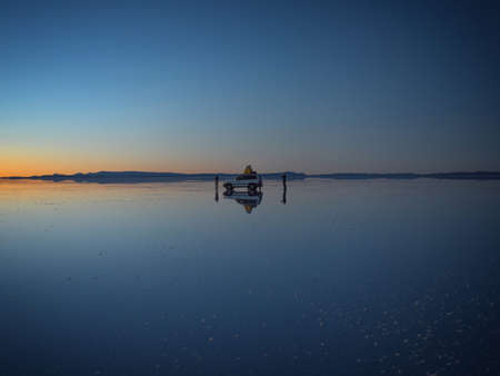Andes mountains sunrise panorama mirror reflection on Salar de Uyuni salt flat lake in Potosi...