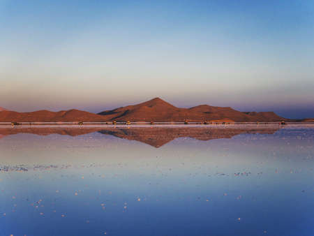 Andes mountains sunrise panorama mirror reflection on Salar de Uyuni salt flat lake in Potosi Bolivia, South Americaの写真素材