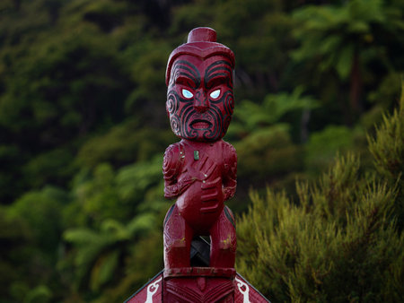 Traditional ancient red wooden Maori sculpture figure in Abel Tasman National Park Tasman South Island New Zealandの写真素材
