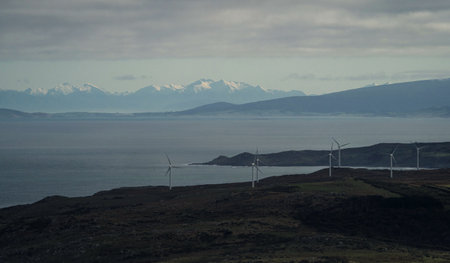 Oceanside clean green renewable energy windmill plant park with snow capped mountain chain in background, Bluff Invercargill Southland South Island New Zealandの写真素材