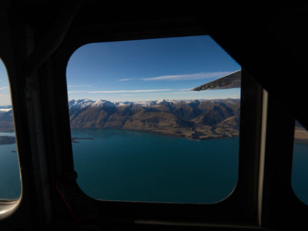 Airplane window seat panorama view of Lake Wakatipu alpine mountain landscape, Southern Alps, Glenorchy, Queenstown, Otago, South Island, New Zealandの写真素材