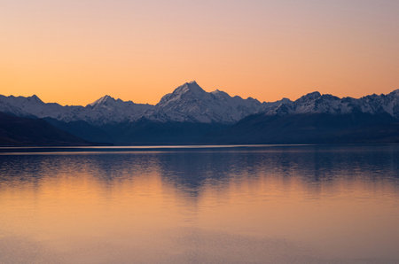 Mount Cook Aoraki mountain mirror reflection panorama view at Lake Pukaki, alpine orange sky sunset...