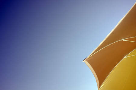 Beach umbrella against sky, with space for titles and wordsの写真素材