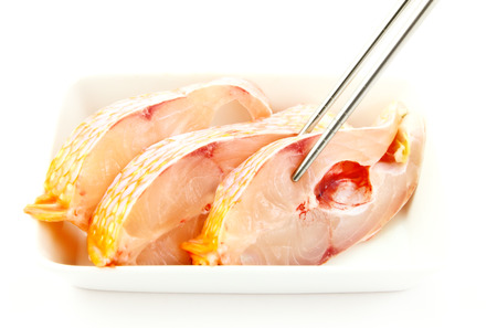 Freshwater fish cut into pieces and shopsticksの写真素材
