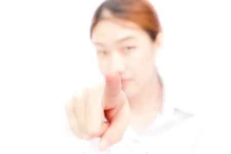 Young woman pointing at you while isolated on a white backgroundの写真素材