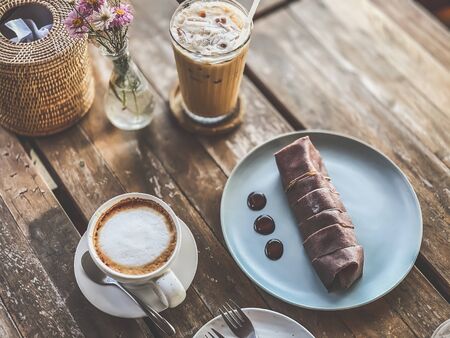 Sweet crape banana chocolate with hot coffee on wood table food and drink backgroundsの写真素材