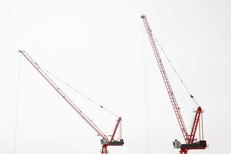 Large construction site including several cranes working on a building complex, with clear blue sky and the sun. Crane construction site / top view.の写真素材