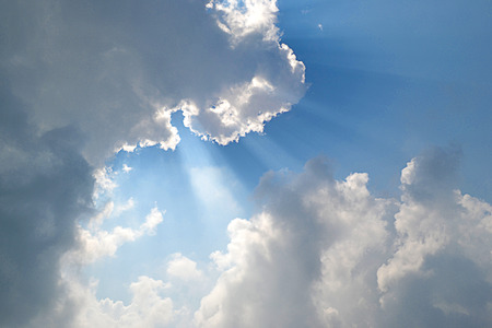 Huge cloud with sun behid them, blue sky with sun flare, sun break throughの写真素材