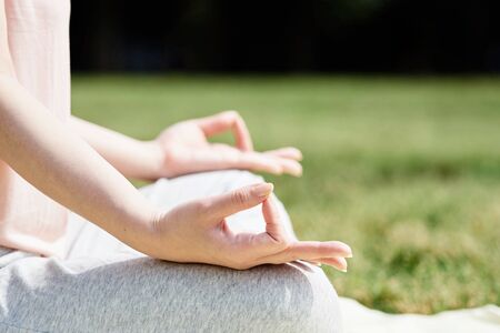The hand of the woman who meditates in the lush nature