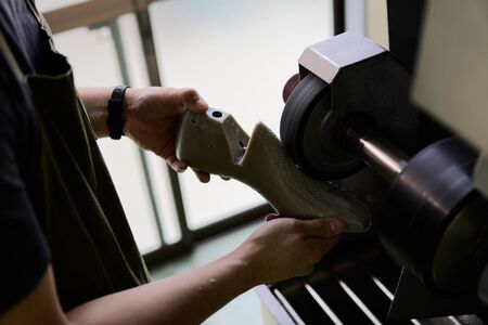 a shoemaker who cuts the shape of a shoe in a workshop