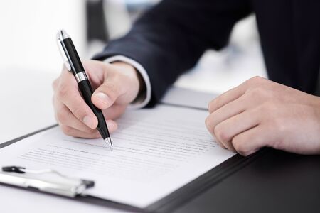 The hand of the Japanese male businessman who signs the documentの写真素材