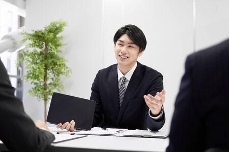 Japanese male businessman explaining face-to-faceの写真素材