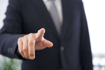 Japanese male businessman pointing at a conference room for text synthesisの写真素材