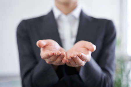 Japanese woman businesswoman holding out her hands in the officeの写真素材