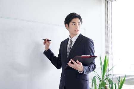 Japanese male businessmen practicing presentationsの写真素材