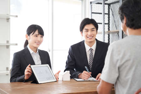 Japanese real estate sales staff who use tablets to explain roomsの写真素材