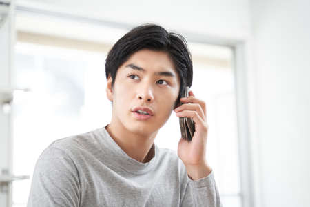 A Japanese man who calls on his smartphoneの写真素材