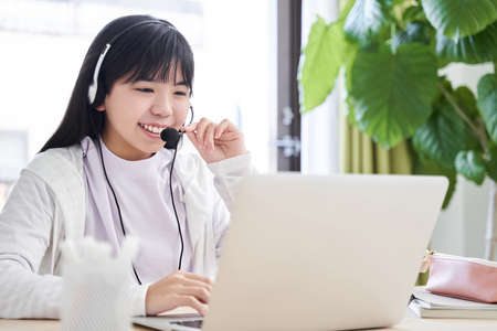 Japanese girls and junior high school students attending an online lecture in the living room