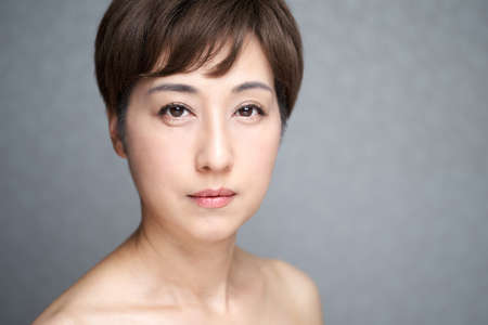 Middle-old Japanese woman looking at camera with serious expressionの写真素材