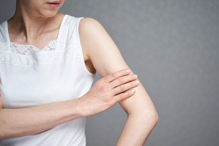 A middle-old Japanese woman who confirms the moisture of her armの写真素材