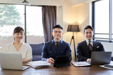 Asian and Latin business person smiling from camera's point of view
