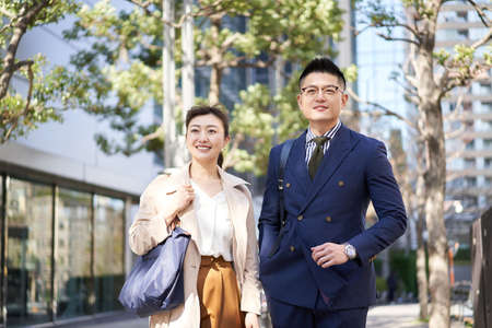 Asian business person walking in business districtの写真素材