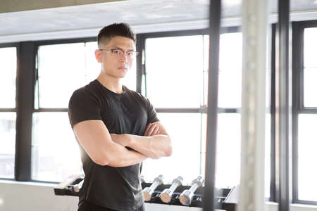 Asian male trainer with arm folds from the camera's point of viewの写真素材