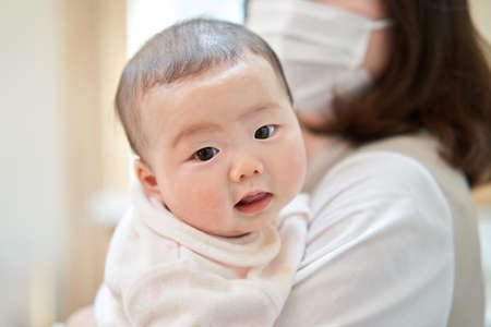 Asian baby cuddled by momの写真素材