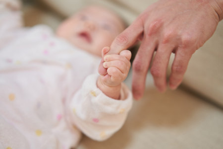 Asian baby holding daddy's fingerの写真素材