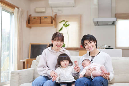 Asian family sitting on sofa from camera's point of viewの写真素材