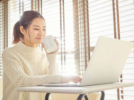 Asian woman using computer at homeの写真素材