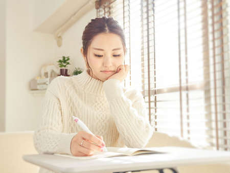 Asian woman with school assignmentsの写真素材