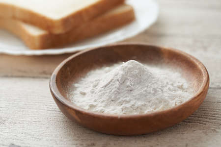 Flour and bread in a wooden bowlの写真素材